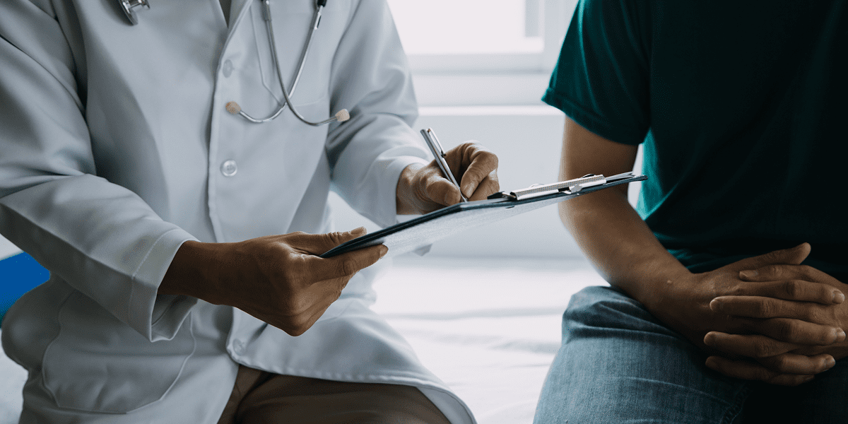 Doctor consulting patient with clipboard discussion.