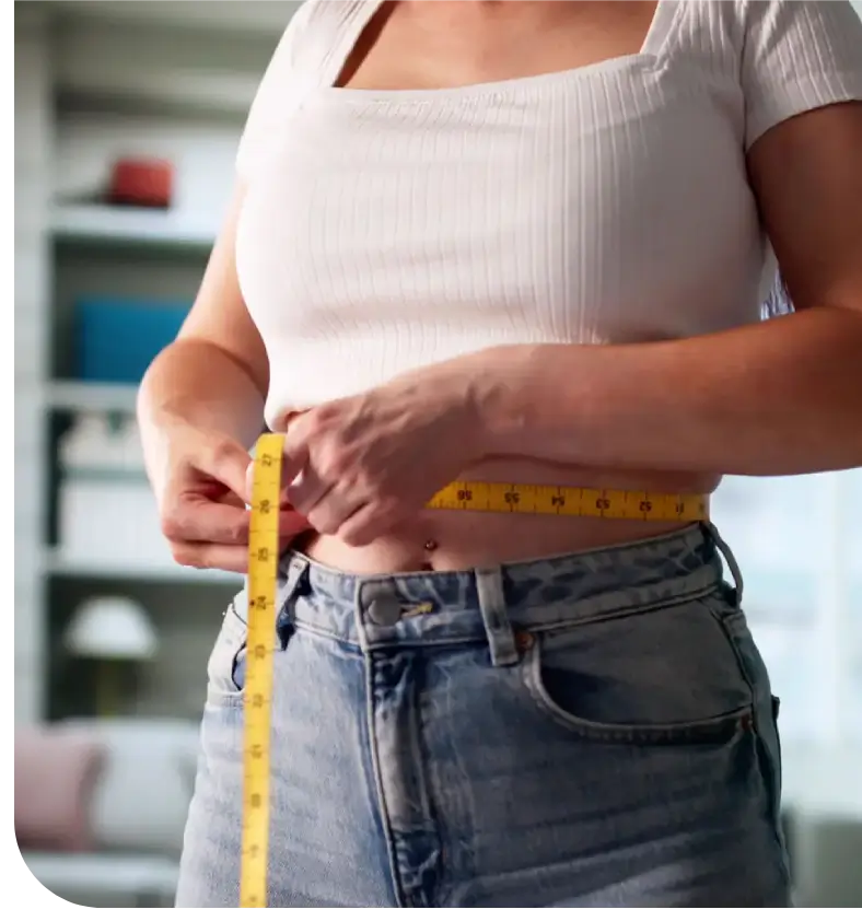 Person measuring waist with a tape measure.