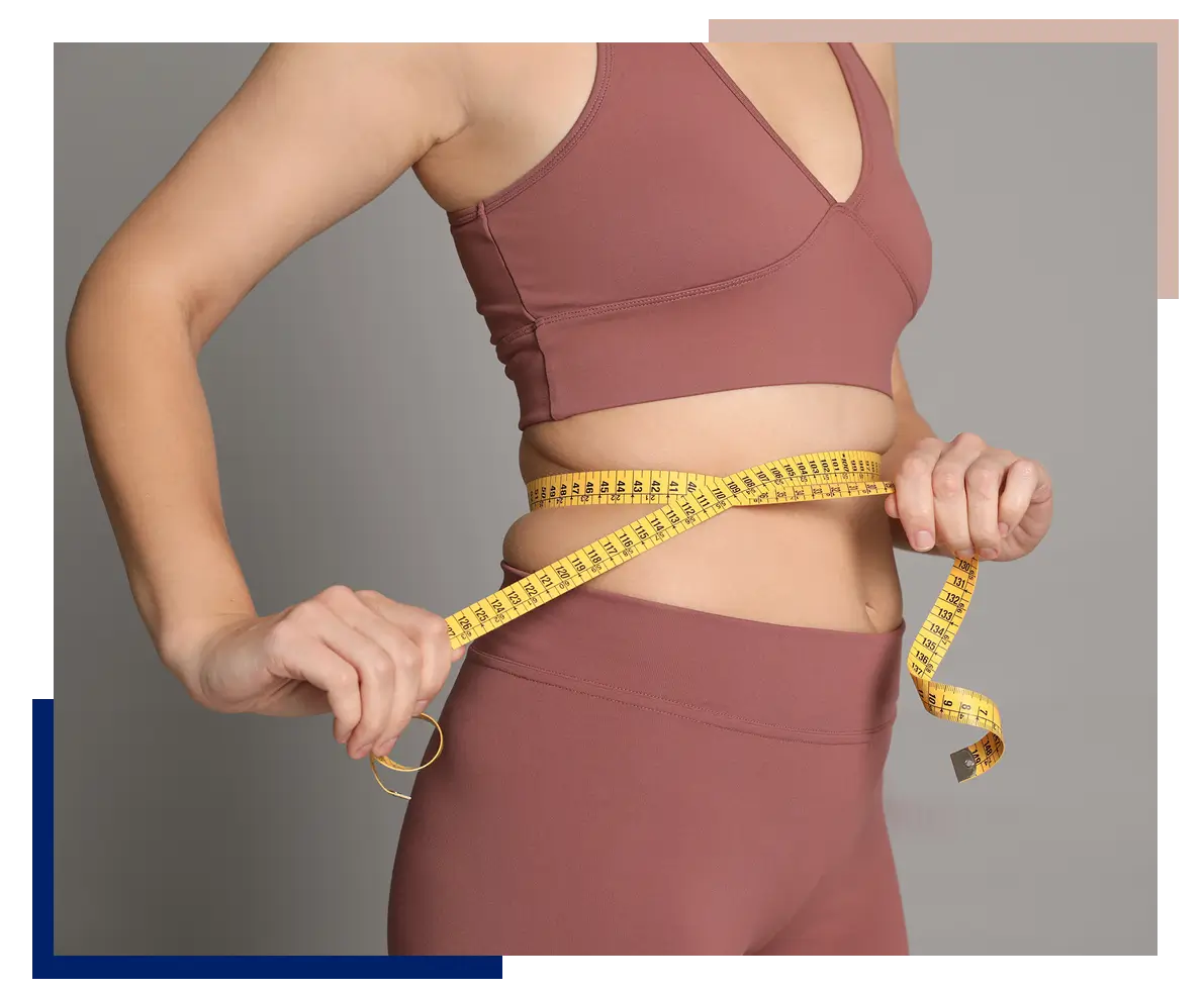Woman measuring her waist with a tape measure.