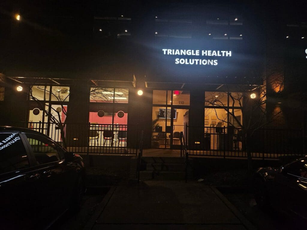 Triangle Health Solutions building at night.